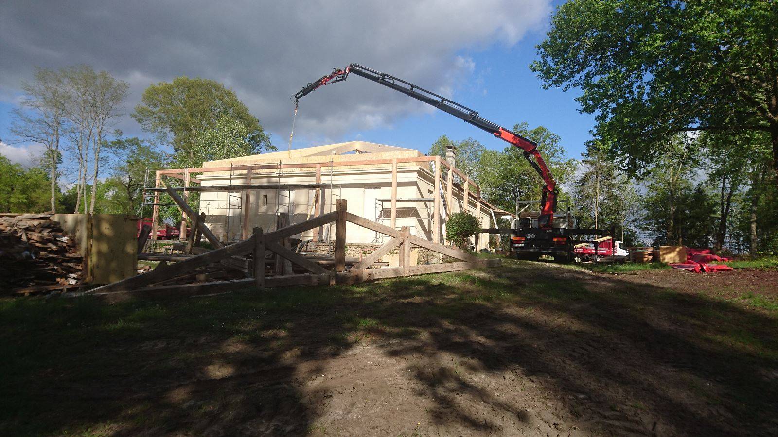 Levage à la grue de poutre en lamellé collé pour une rénovation de charpente d'une maison en Gironde