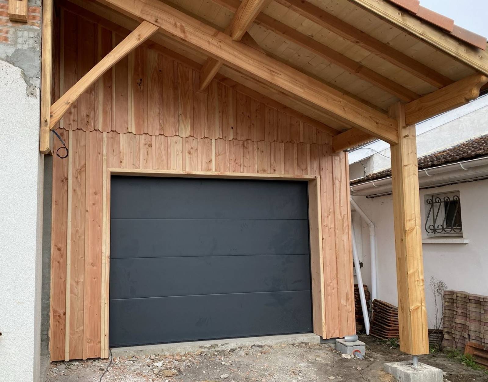 Réalisation d'une avancé de toiture de toiture sur poteau et pose d'un bardage bois