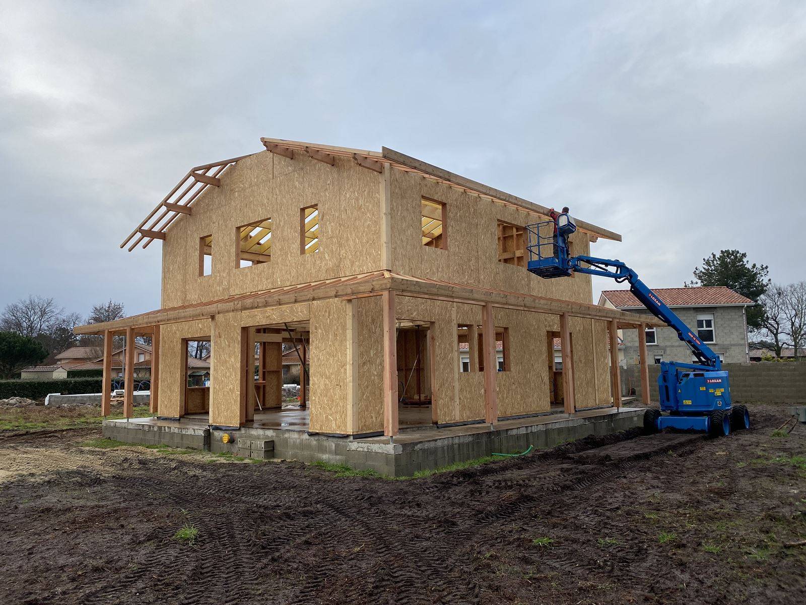 Pose de bandeaux bois sur une charpente traditionnelle à l'aide d'une nacelle dans les Landes